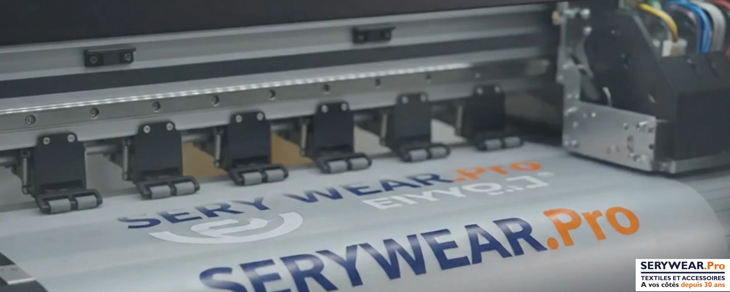 Imprimante DTF en cours d'impression des logos SERYWEAR.Pro sur un film de transfert pour la personnalisation textile.
