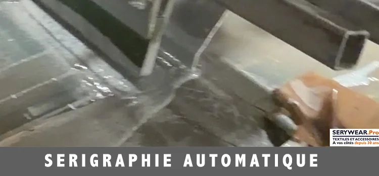 Machine de sérigraphie automatique en fonctionnement pour l'impression de textiles personnalisés dans l'atelier SERYWEAR.Pro.
