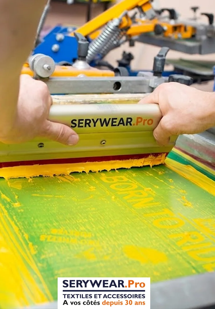 Opérateur réalisant une impression en sérigraphie avec une racle sur un écran de marquage textile dans l'atelier SERYWEAR.Pro.